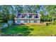 View of home with solar panels, teal shutters and large front deck from a high vantage point on the lawn at 6357 Highway 707, Myrtle Beach, SC 29588