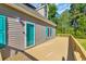 Exterior featuring a charming home with a large deck, teal shutters, and a matching teal front door at 6357 Highway 707, Myrtle Beach, SC 29588