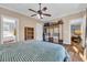 Main bedroom with wood-look floors, ceiling fan, and a glimpse into the bathroom and closet at 6357 Highway 707, Myrtle Beach, SC 29588
