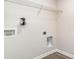 A laundry room with white walls, wood-look floors, wire shelving, and essential utility connections at 647 Culmen Ct., Myrtle Beach, SC 29588