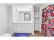 Bright bathroom features a double vanity with white cabinets and a colorful shower curtain at 66 Lakeview Circle # 106, Pawleys Island, SC 29585