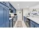 The kitchen features sleek blue cabinets, stainless steel appliances, and bright white countertops at 66 Lakeview Circle # 106, Pawleys Island, SC 29585