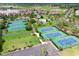 Aerial view of tennis courts and pool surrounded by lush greenery and charming residential area at 66 Lakeview Circle # 106, Pawleys Island, SC 29585