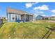 Expansive backyard featuring a screened-in porch, lush green grass, and a peaceful view of the pond at 684 Wailea Circle, Little River, SC 29566