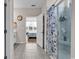 Bathroom showcasing tile floors, a shower with blue floral curtain, and a view of the bedroom at 684 Wailea Circle, Little River, SC 29566