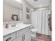 Neutral bathroom featuring a single sink vanity and a shower with a white curtain at 684 Wailea Circle, Little River, SC 29566