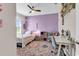 Stylish bedroom with a canopy bed, colorful rug, and lilac accent wall at 684 Wailea Circle, Little River, SC 29566
