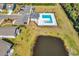 Aerial view of the community pool and amenity center with a parking lot and pond nearby at 684 Wailea Circle, Little River, SC 29566