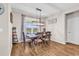 Bright dining room with a modern chandelier, large window, and hardwood flooring overlooking the backyard at 684 Wailea Circle, Little River, SC 29566