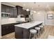 Modern kitchen boasts a large island with seating, sleek cabinets, stainless steel appliances, and hardwood floors at 7075 Denim Loop, Myrtle Beach, SC 29579