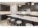 Spacious kitchen featuring dark wood cabinets, a large island with seating, and modern stainless steel appliances at 7075 Denim Loop, Myrtle Beach, SC 29579