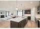Open-concept kitchen with a large island, dark cabinetry, stainless steel appliances, and hardwood floors at 7075 Denim Loop, Myrtle Beach, SC 29579