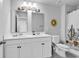 Bathroom featuring double sinks, decorative mirrors, a bathtub with shower and neutral wall color at 732 Mustang Ranch Dr., Myrtle Beach, SC 29588