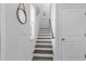 Light-filled stairway with white risers, gray treads, decorative mirrors and a door to the upper level at 732 Mustang Ranch Dr., Myrtle Beach, SC 29588