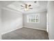 An empty bedroom with carpet, ceiling fan, trey ceiling, and a window at 901 Knoll Shores Ct. # 304, Murrells Inlet, SC 29576