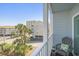 Serene balcony with chair offering lovely views of palm trees, buildings, and blue skies at 9581 Shore Dr. # 216, Myrtle Beach, SC 29572