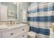 Well-appointed bathroom with vanity, mirror, toilet, and a beautifully striped shower curtain at 9581 Shore Dr. # 216, Myrtle Beach, SC 29572
