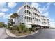 Coastal condo building featuring multiple balconies, palm trees, and covered parking at 9581 Shore Dr. # 216, Myrtle Beach, SC 29572