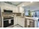 Bright kitchen featuring white cabinets, stainless steel appliances, and an open layout to the dining area at 9581 Shore Dr. # 216, Myrtle Beach, SC 29572