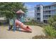 Colorful community playground, with a slide, climbing structure, and sand for active play at 9581 Shore Dr. # 216, Myrtle Beach, SC 29572