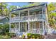 Charming two-story home with a double front porch and inviting outdoor seating area at 99 Berry Tree Dr., Pawleys Island, SC 29585