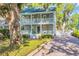 Inviting two-story home with double porches and a brick driveway lined with lush greenery at 99 Berry Tree Dr., Pawleys Island, SC 29585