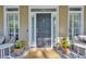 Elegant front door with sidelights, decorative house number, and potted plants adding charm at 99 Berry Tree Dr., Pawleys Island, SC 29585