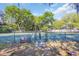 Fenced-in tennis court surrounded by mature trees providing ample shade at 99 Berry Tree Dr., Pawleys Island, SC 29585
