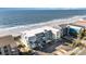 Aerial view of the condo complex, beach, and ocean with palm trees and parking lot at 1011 S Ocean Blvd., Surfside Beach, SC 29575