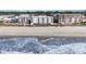 Beach view showing ocean waves, sand, and exterior of condo buildings near the coastline at 1011 S Ocean Blvd., Surfside Beach, SC 29575