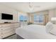 Bright bedroom with large windows, balcony access, and a wooden dresser at 1011 S Ocean Blvd., Surfside Beach, SC 29575