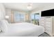 Bright bedroom boasts ocean views from the bed, a private balcony, and a white dresser for ample storage at 1011 S Ocean Blvd., Surfside Beach, SC 29575