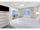 Bright bedroom with a ceiling fan, large windows with ocean views, and a white dresser at 1011 S Ocean Blvd., Surfside Beach, SC 29575