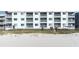 Low-angle exterior shot of a beachside residential building, showcasing balconies, access to the beach and stairs at 1011 S Ocean Blvd., Surfside Beach, SC 29575