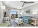 Relaxing living room with a comfortable couch, ceiling fan, and ocean view balcony access at 1011 S Ocean Blvd., Surfside Beach, SC 29575