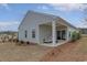 View of a covered back porch with a stylish outdoor seating area and sliding glass door at 1013 Hainer Place Dr, Conway, SC 29526