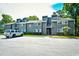 View of building exterior with gray wood siding, windows, roof access, landscaping, and asphalt parking lot at 10301 N Kings Hwy. # 21-5, Myrtle Beach, SC 29572