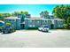 Exterior of building showing units with gray siding, a parking area, green space, and mature trees at 10301 N Kings Hwy. # 21-5, Myrtle Beach, SC 29572