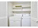 Functional laundry room with a white washer and dryer, and built in shelving at 10301 N Kings Hwy. # 21-5, Myrtle Beach, SC 29572
