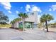 Exterior view of the Ocean One building with manicured palm trees and welcoming entrance, showcasing coastal charm at 107 S Ocean Blvd. # 1402, Myrtle Beach, SC 29577