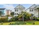 Charming two-story coastal home with a welcoming front porch, lush landscaping, and a well-maintained green lawn at 113A 9Th Ave. S, Surfside Beach, SC 29575