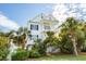 Charming two-story white home with double balconies and lush tropical landscaping at 113A 9Th Ave. S, Surfside Beach, SC 29575
