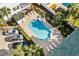 An aerial view of a community pool area with ample seating, meticulous landscaping, and several parked cars at 113A 9Th Ave. S, Surfside Beach, SC 29575
