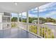 Screened porch with gray wood flooring boasting neighborhood views and blue skies at 113A 9Th Ave. S, Surfside Beach, SC 29575
