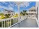Covered porch with gray wood floors overlooking lush landscaping and neighborhood at 113A 9Th Ave. S, Surfside Beach, SC 29575