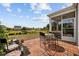 Patio with dining table, chairs, and access to a screened-in porch overlooks a serene backyard pond at 125 Mountain Ash Ln., Myrtle Beach, SC 29579