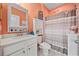 Cheerful bathroom with coral walls, decorative accents, and shower with gray and white striped curtain at 125 Mountain Ash Ln., Myrtle Beach, SC 29579