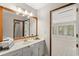 A well-lit bathroom featuring a vanity with a framed mirror and a view into the adjacent sunroom at 1314 Holly Dr., North Myrtle Beach, SC 29582
