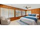 Bedroom featuring wood paneling, bed, and an accent chair with multiple windows at 1314 Holly Dr., North Myrtle Beach, SC 29582