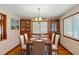 Traditional dining room with wood table, upholstered chairs, china cabinets, a decorative light fixture, and a large window at 1314 Holly Dr., North Myrtle Beach, SC 29582
